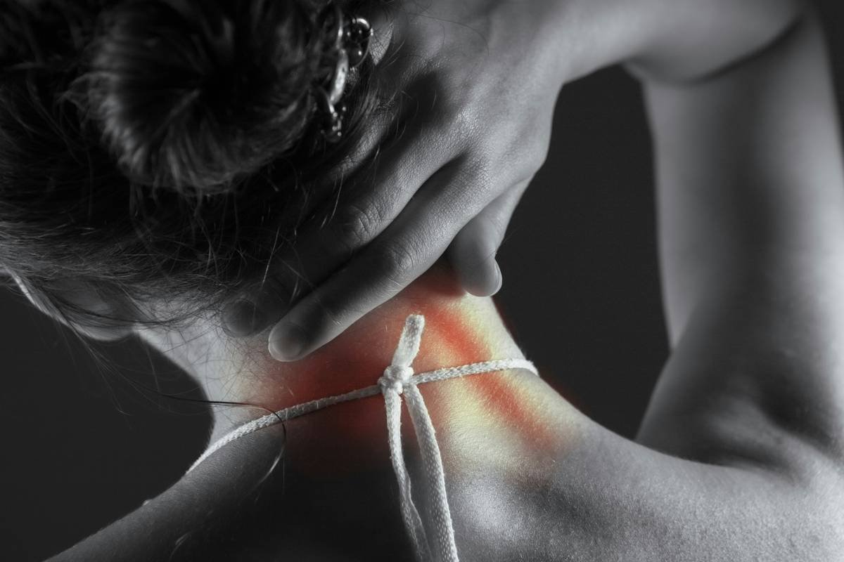 Woman using handheld RF device on neck with tools to tighten neck skin visible on vanity
